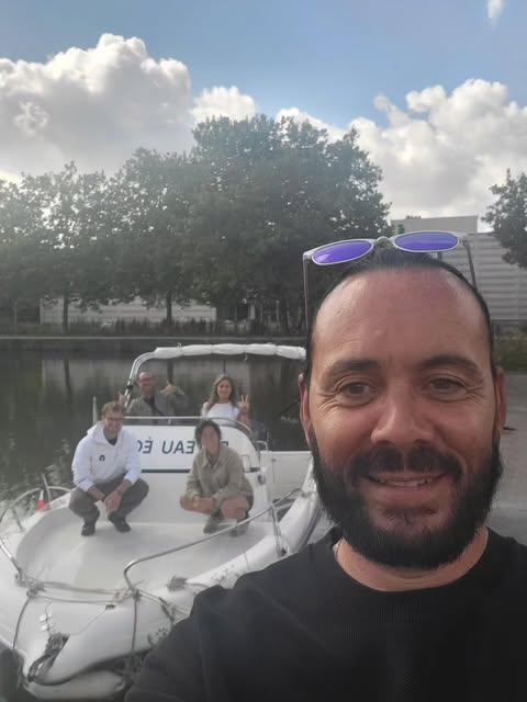 Vincent, souriant, devant le bateau-école au port de Nancy